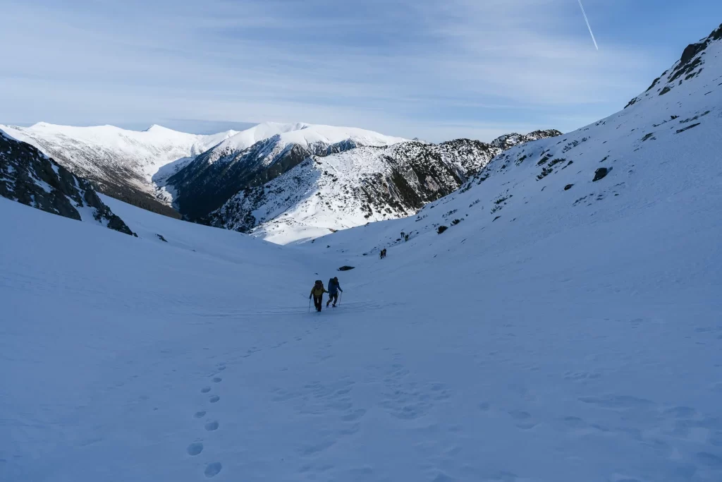 Hikers ascending a snowy pass