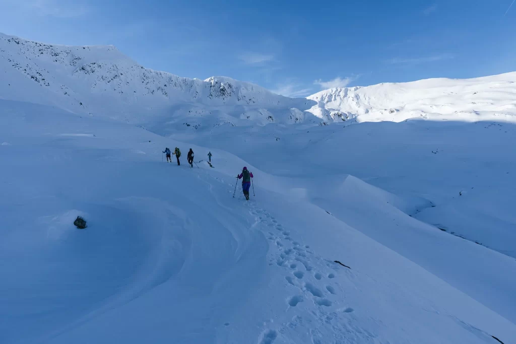 Hikers ascending a snowy pass