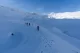 Hikers ascending a snowy pass