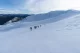 Snowfield with distant hikers