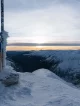 Frozen Romanian flag at Moldoveanu Peak during sunset