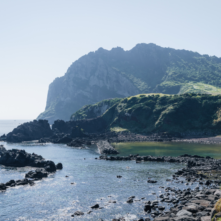 Rocky shoreline leading to Seongsan Ilchulbong’s cliffs