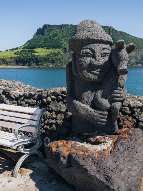 Dol Hareubang statue with Seongsan Ilchulbong in the background